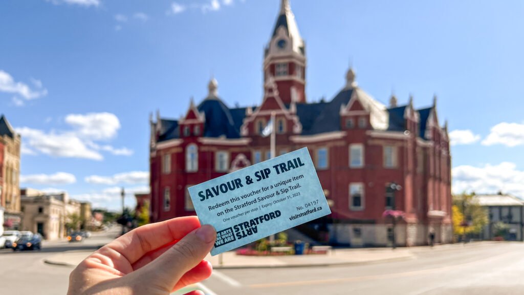 Savour & Sip Trail Stratford | Krista the Explorer Hand holding a blue Savour & Sip Trail voucher.
