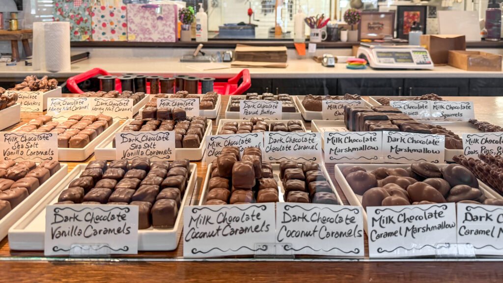 Chocolate Stratford | Krista the Explorer Rows of small chocolates lined up in display case in chocolate shop.