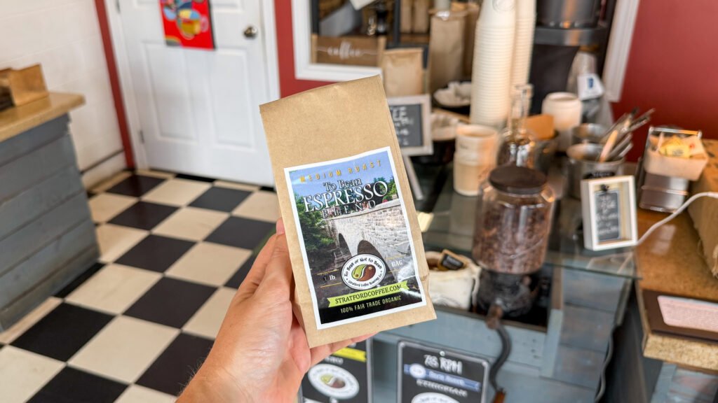 Roastery Stratford | Krista the Explorer Person holding bag of roasted coffee beans in shop.
