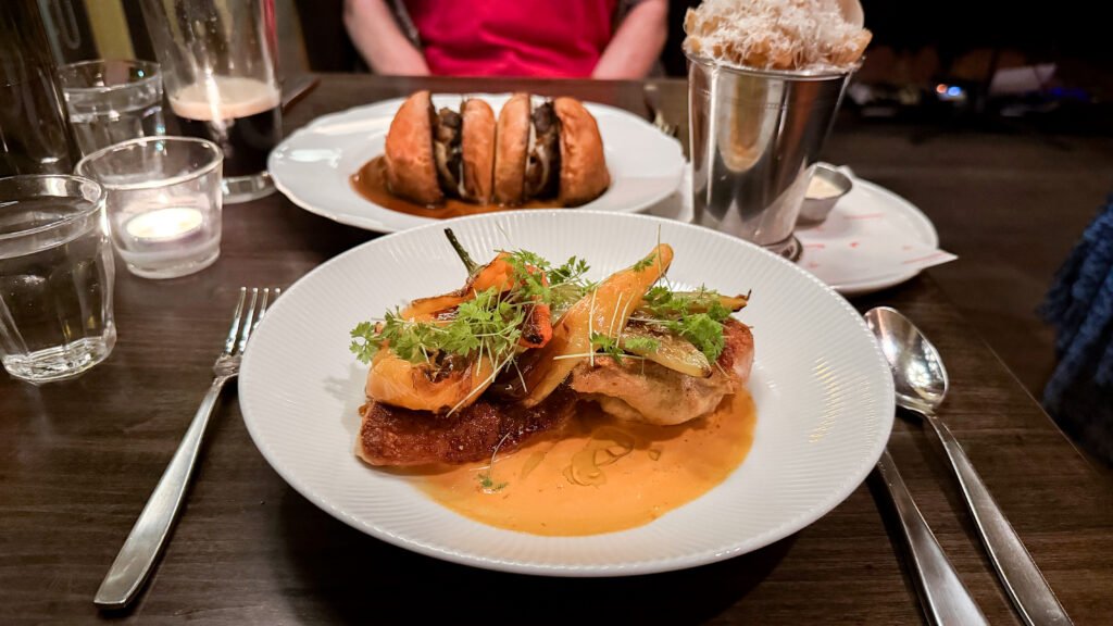 The Starlight Stratford | Krista the Explorer Half-chicken with orange sauce and burger cut in half sitting in gravy.