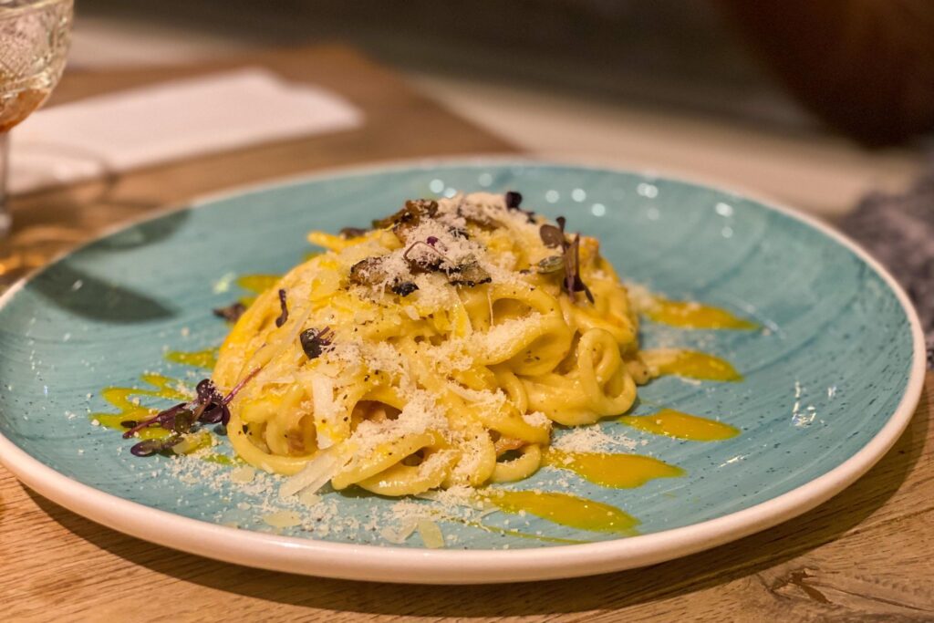 Blue plate with carbonara on it places to eat in London.