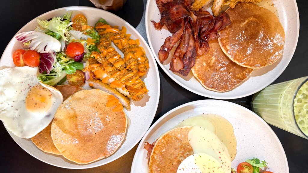 Three white plates stacked with savoury pancakes.
