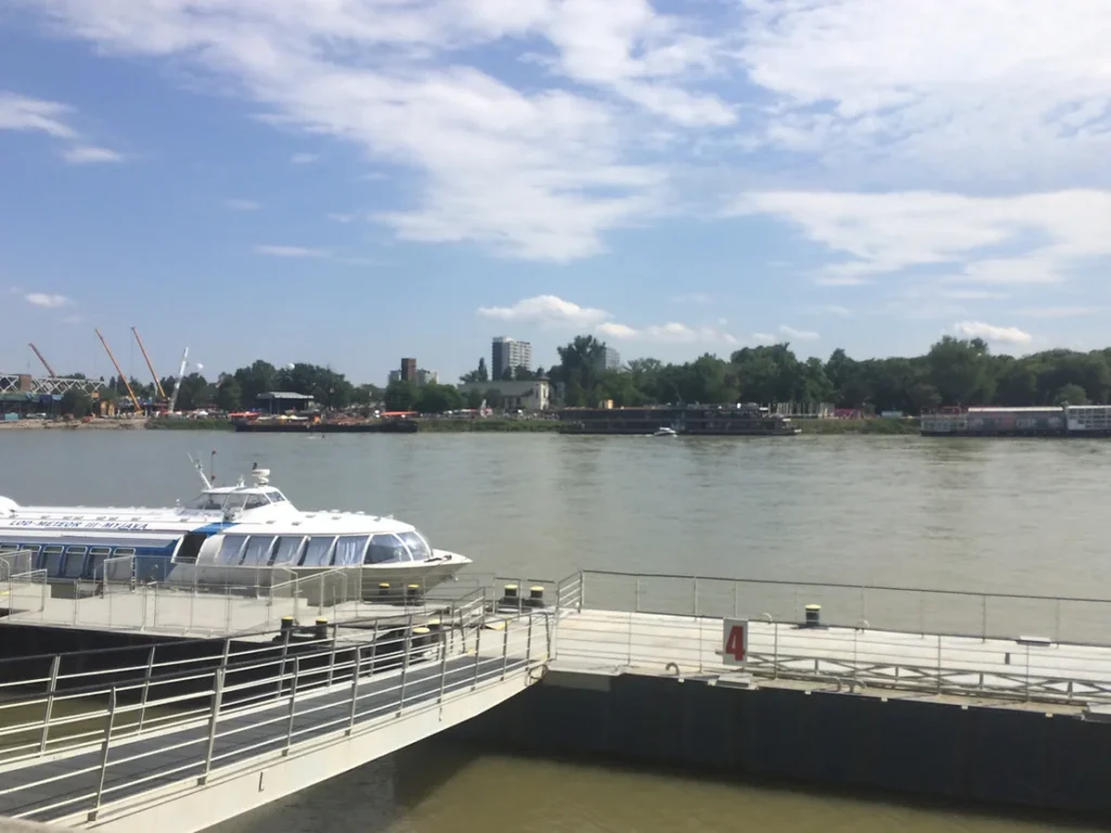 View of the river in Bratislava with a boat on it.
