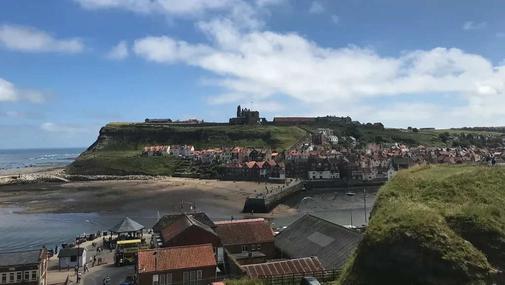 View of Whitby cathedral from West Cliff with bay in foreground.