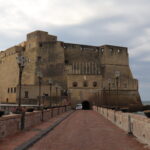 Large medieval castle along waterfront in Naples.