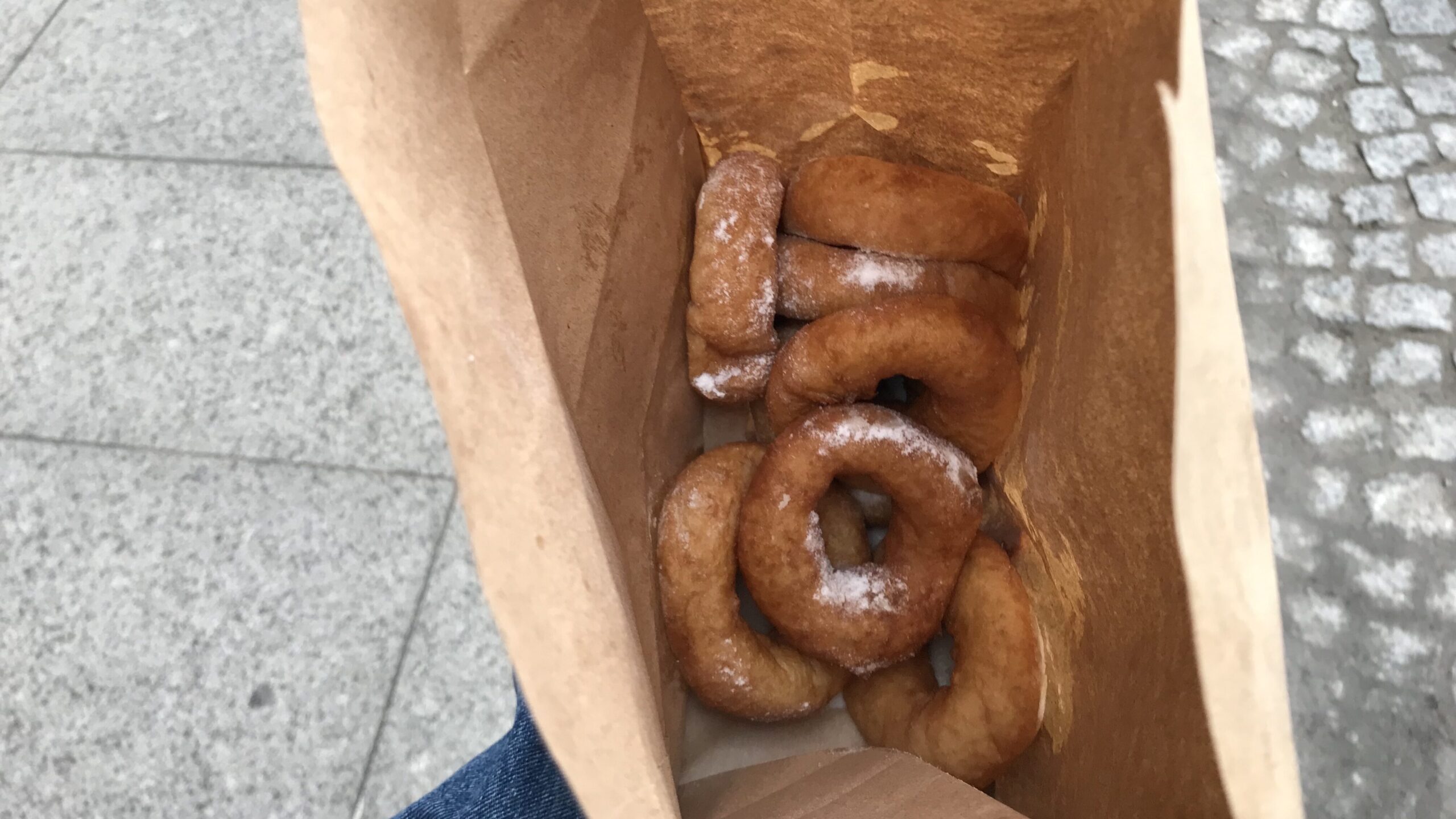 Fresh doughnuts with sugar in paper bag.