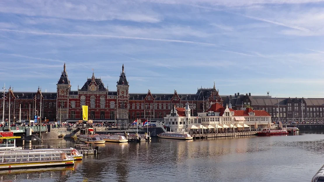 View of a train station across the canal during 1 day in Amsterdam.