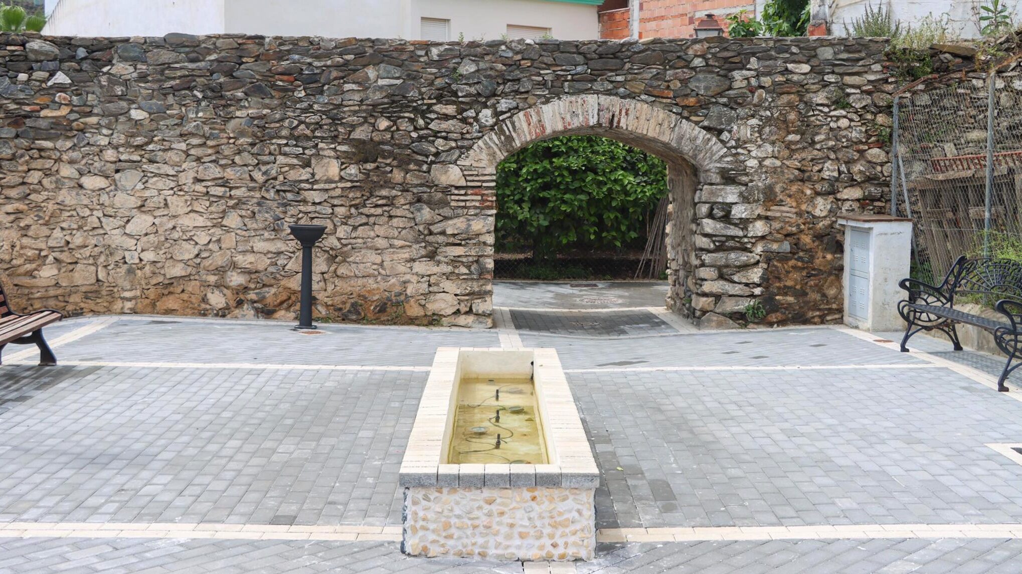 Small historical stone arch in white village.