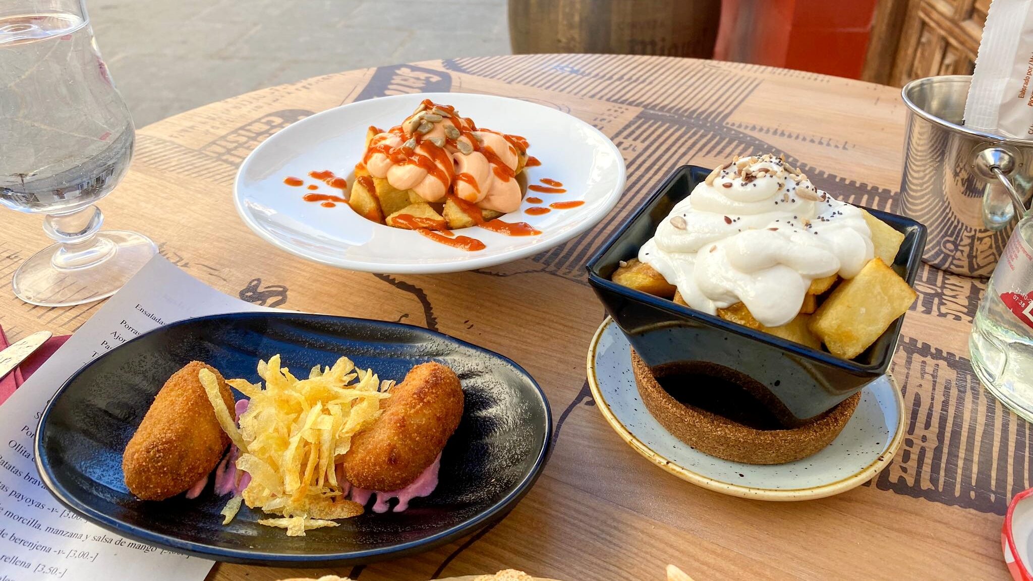 Tapas dishes sitting on barrel outside restaurant.