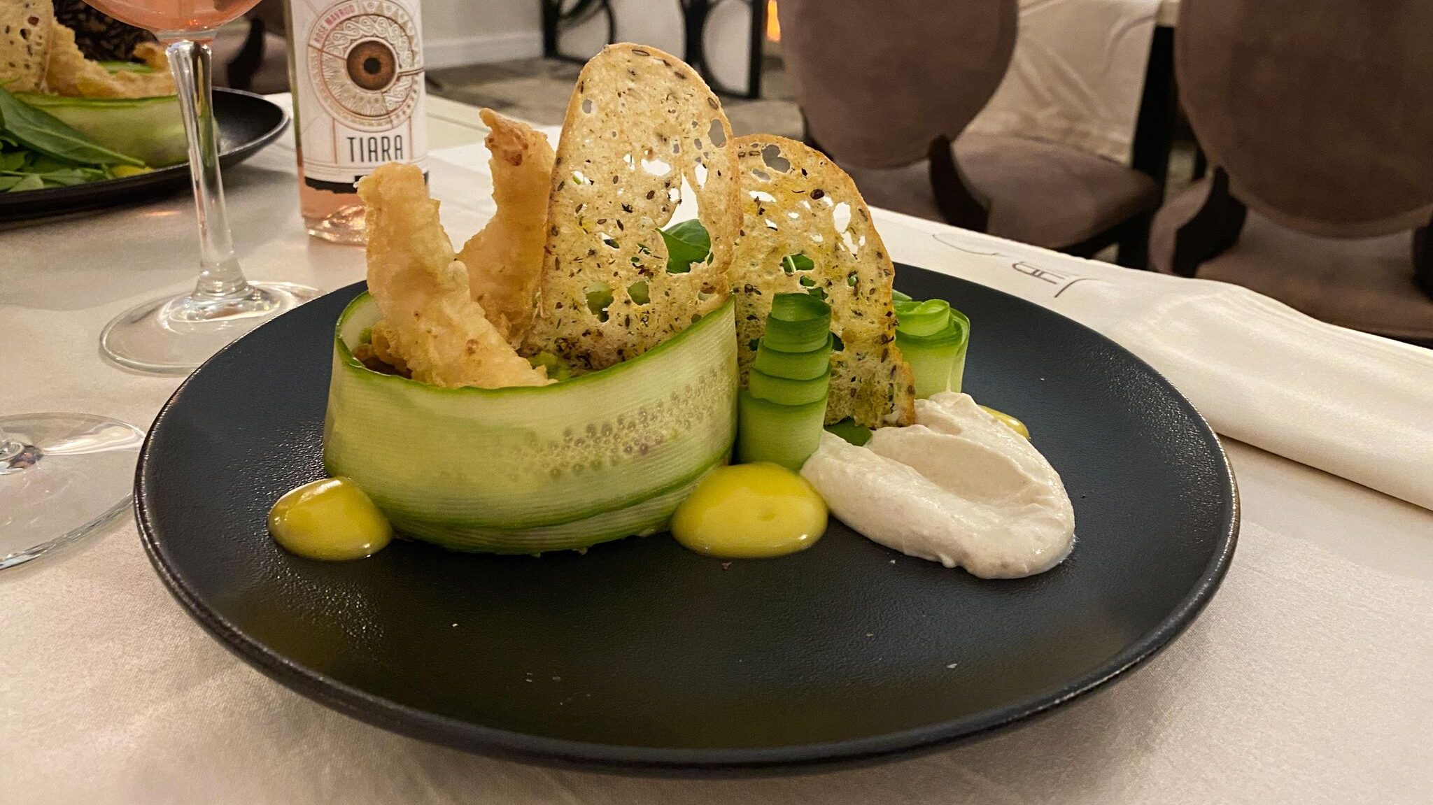 Salad served on black plate.