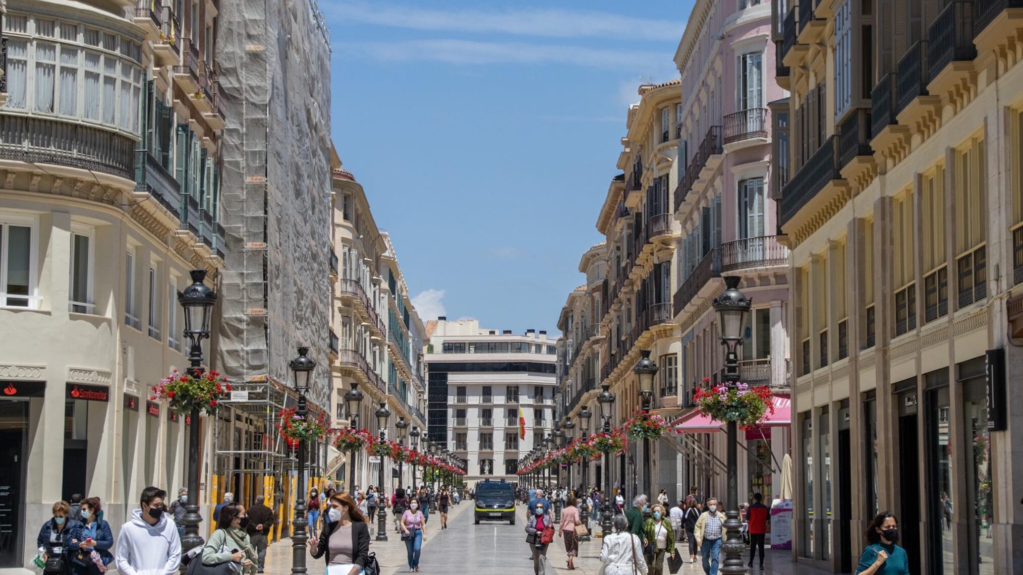 Historical street in Malaga lined with shops.