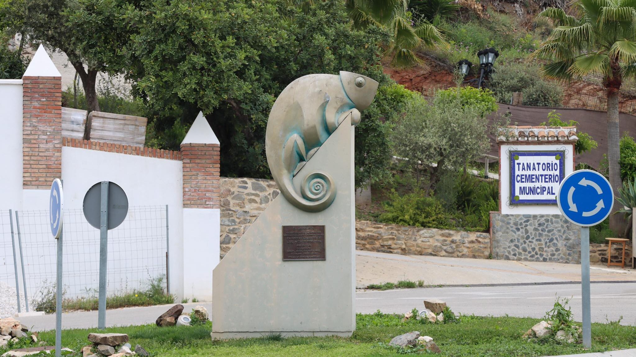 Large statue of a chameleon at village entrance. 