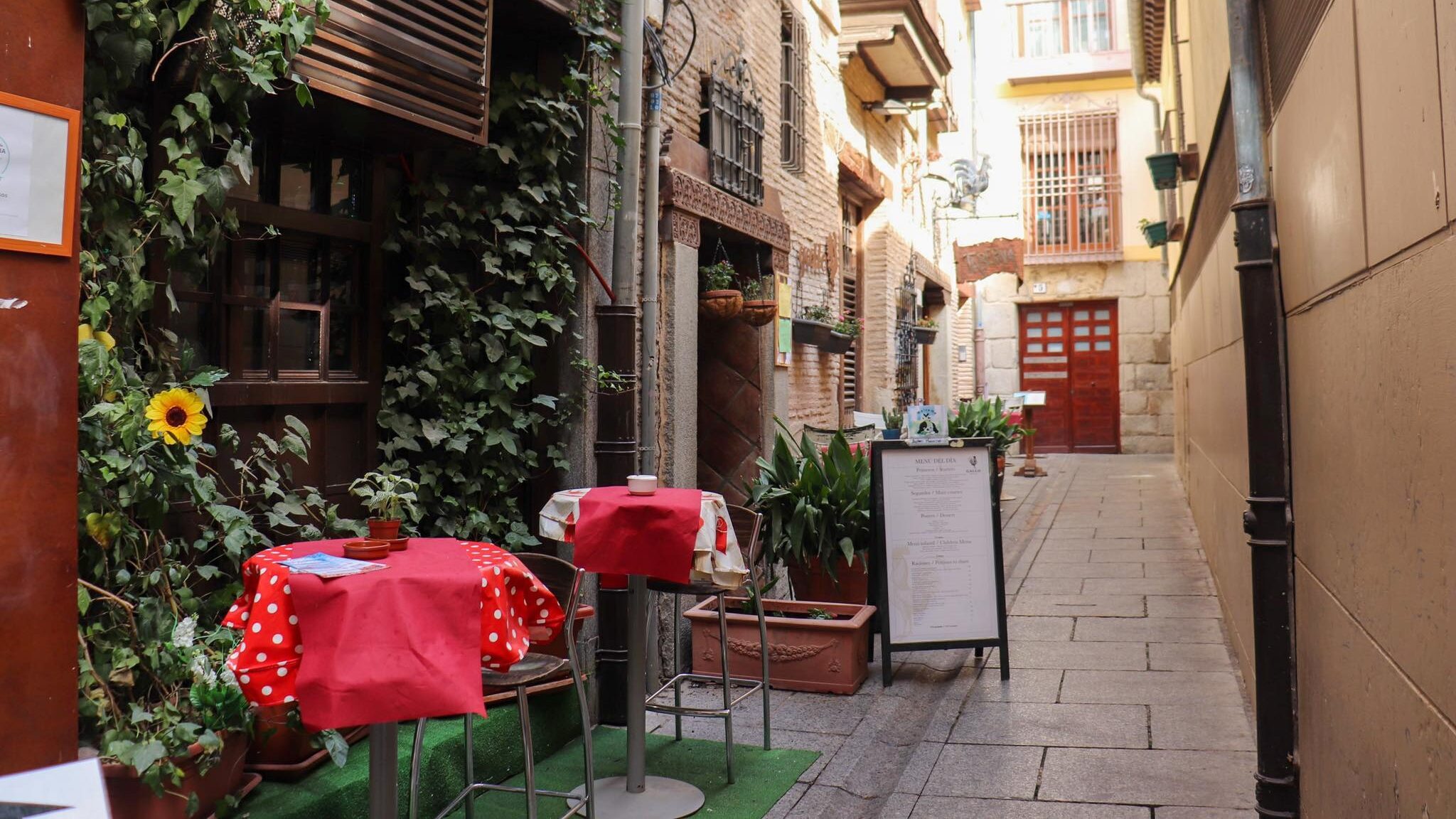 Small alley in Toledo with table and chairs.