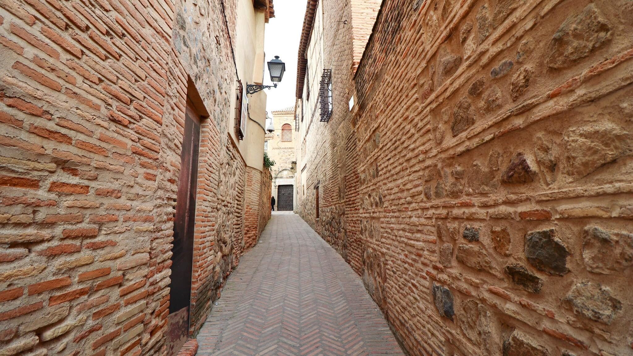 Old town street in Toledo with orange bricks.