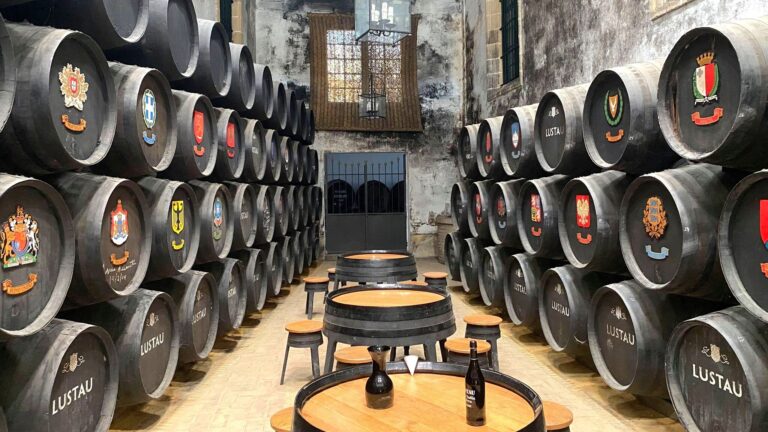 Room full of sherry casks with flags on them.