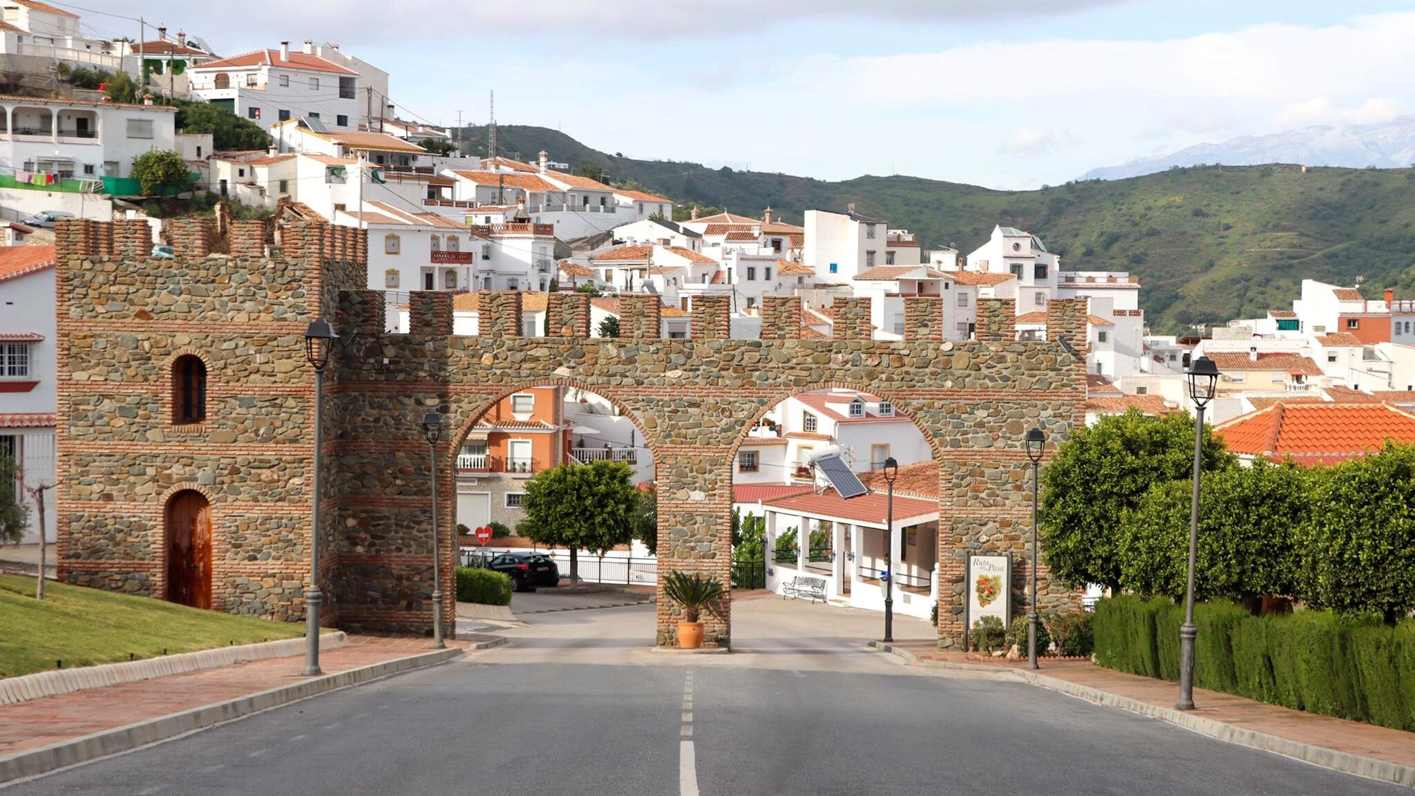 Entrance to white village through brick arches.