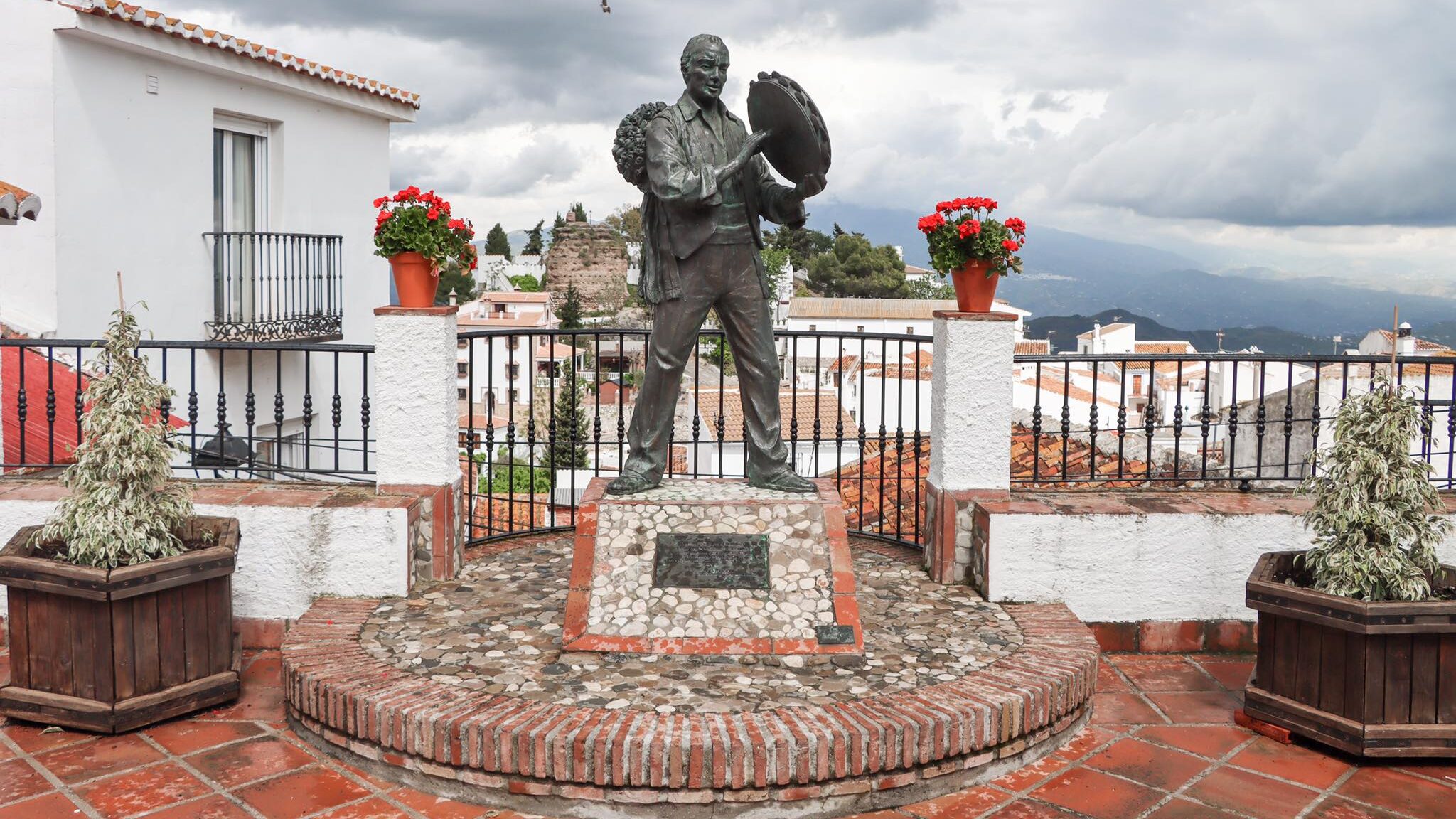 Statue of musician at viewpoint in village.