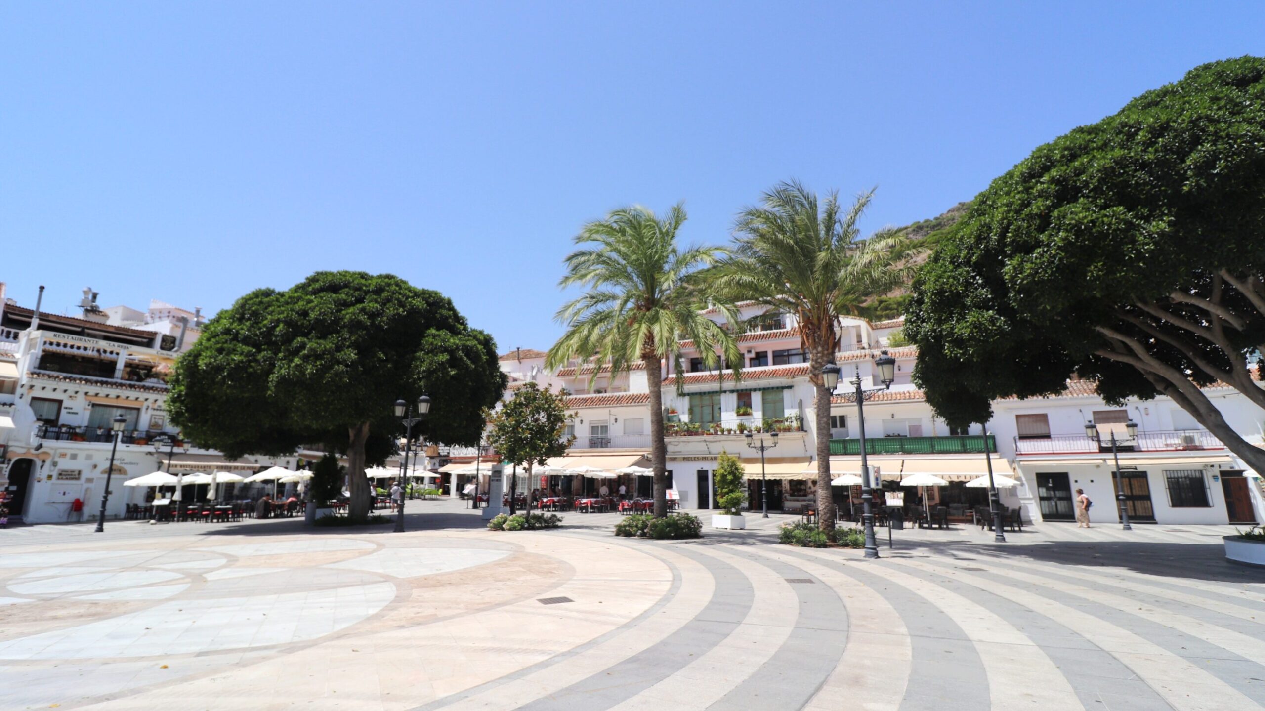 Large plaza with white buildings.