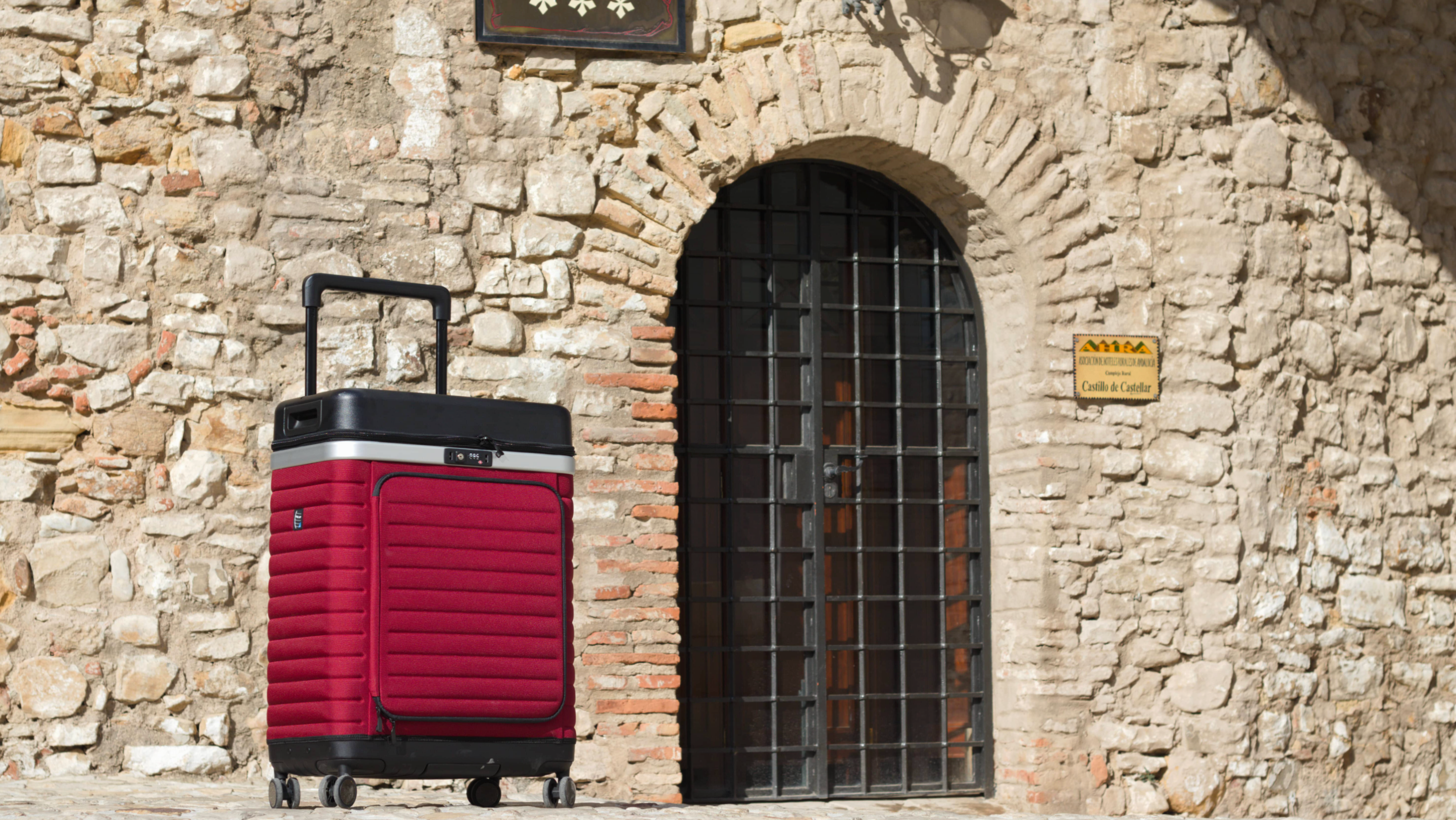 Red Pull Up Suitcase in front of hotel door.