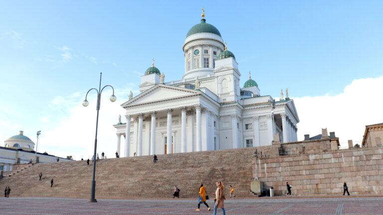 White cathedral in large square in Helsinki.