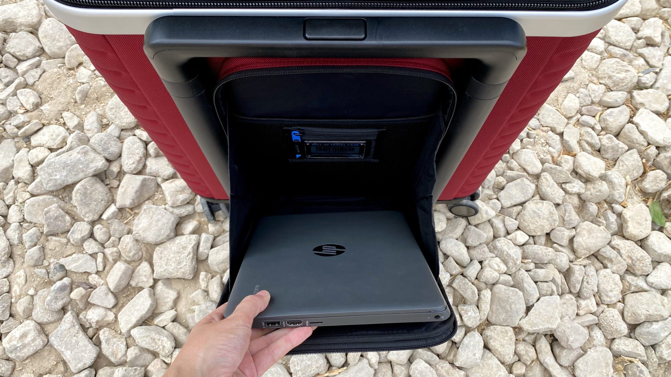 Laptop sleeve on the front of a suitcase.