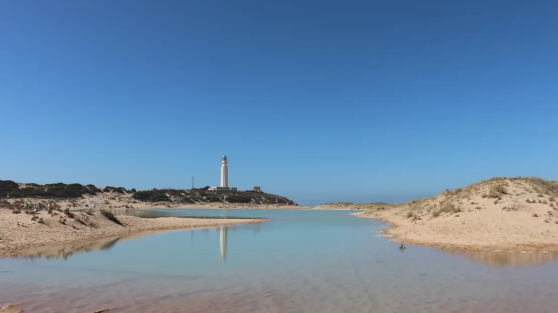 Lighthouse on sand dune along Andalusian coast.