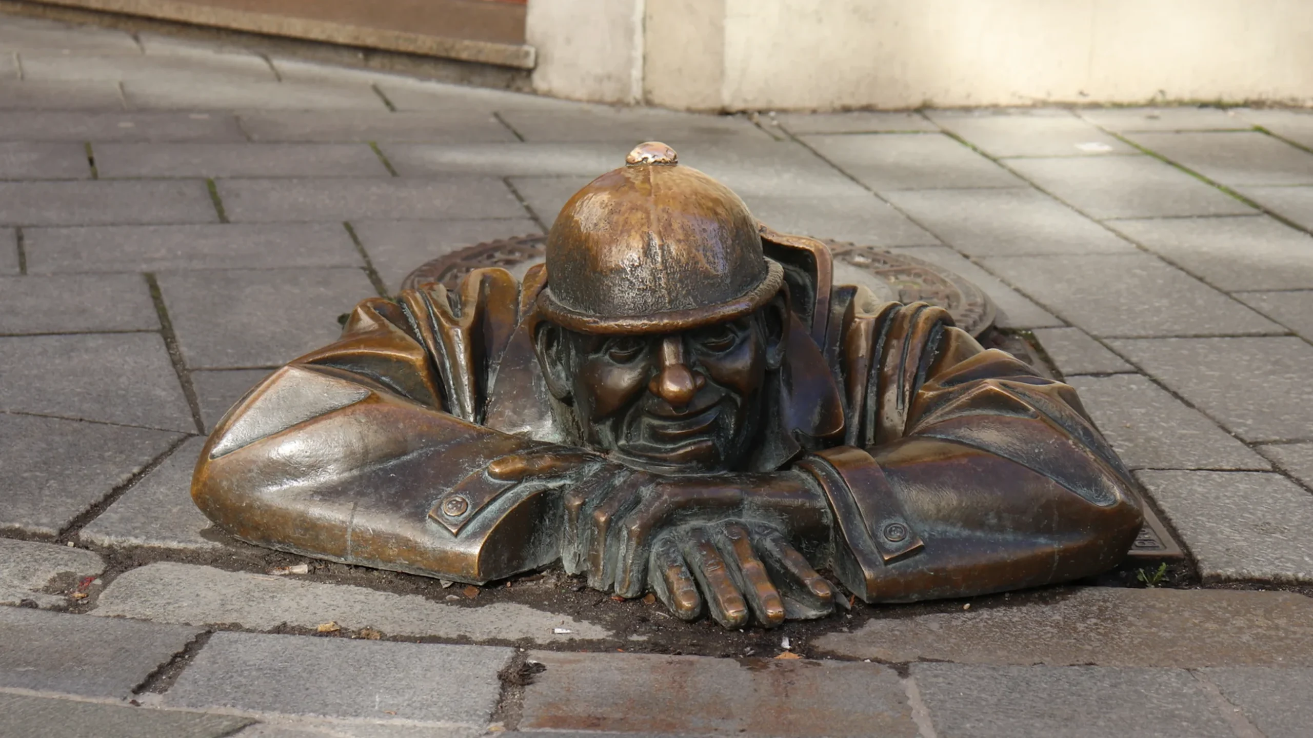 Statue of man coming out of hole in ground.