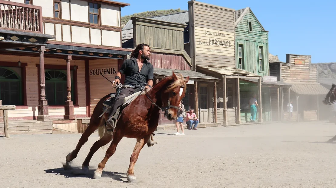 Horse with rider on country western street.