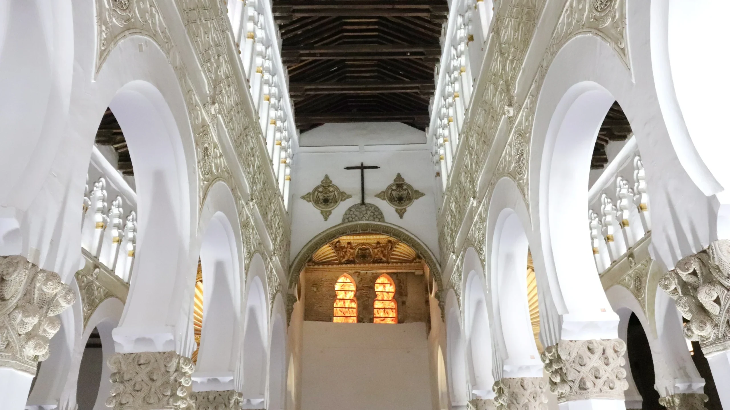 Interior of synagogue in Toledo with white walls.