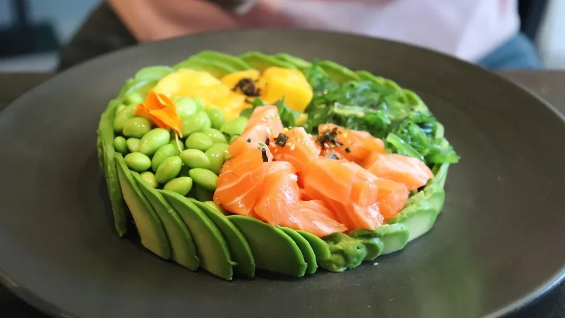 Poke bowl with rim made of avocado.