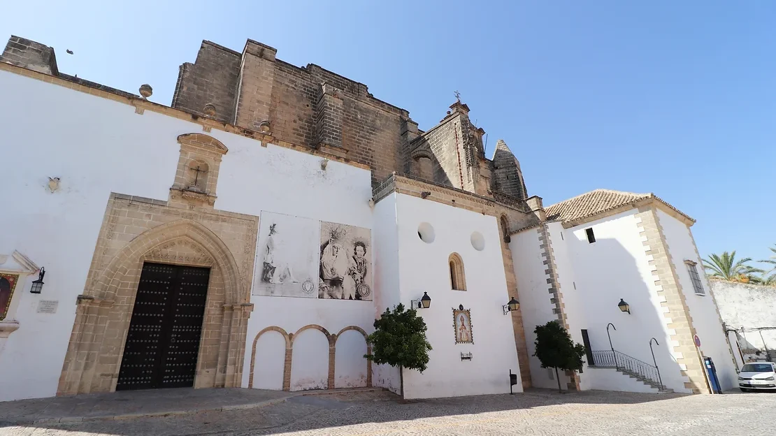 Medieval church behind white painted building.