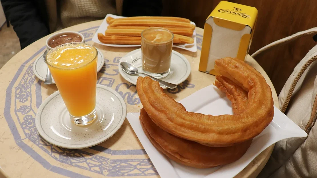 Extra large piece of churro with orange juice.