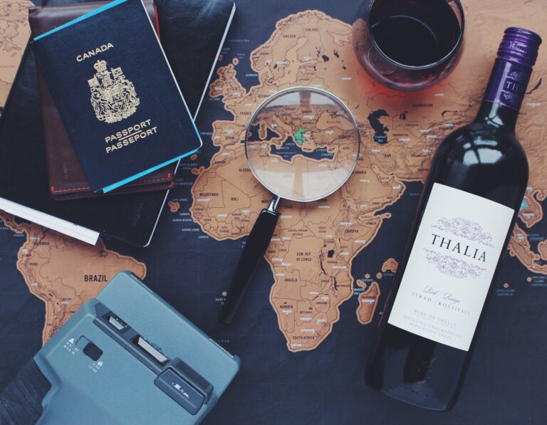 Map with passport and wine bottle on top.