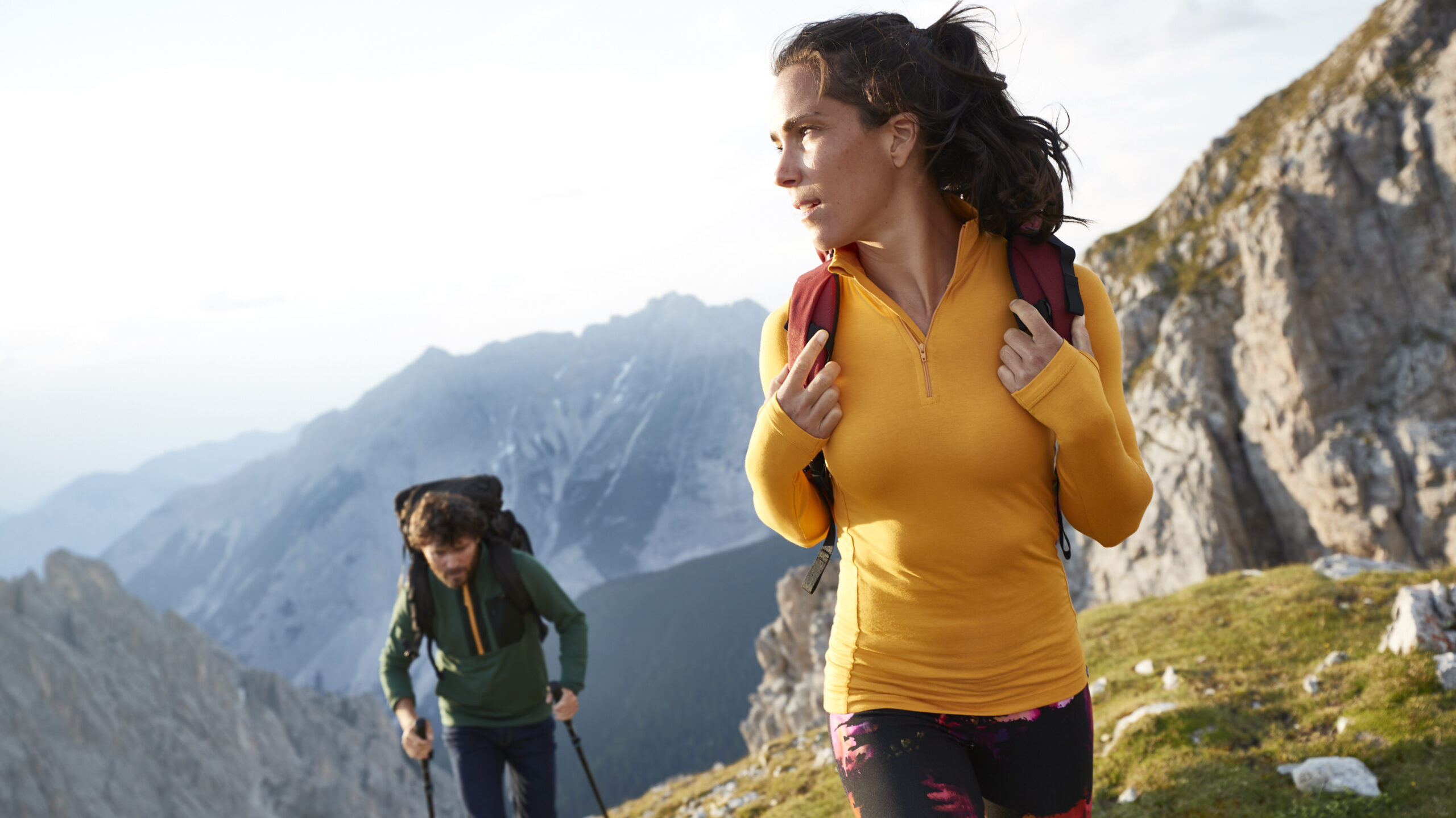 Two people hiking wearing base layers.