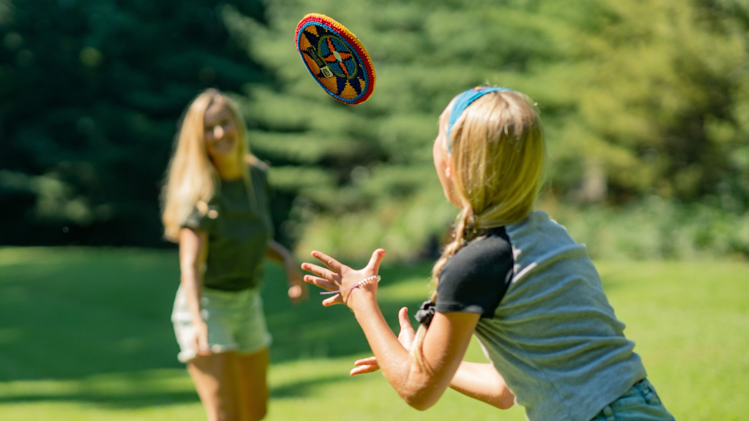 Knitted frisbee being thrown in field.