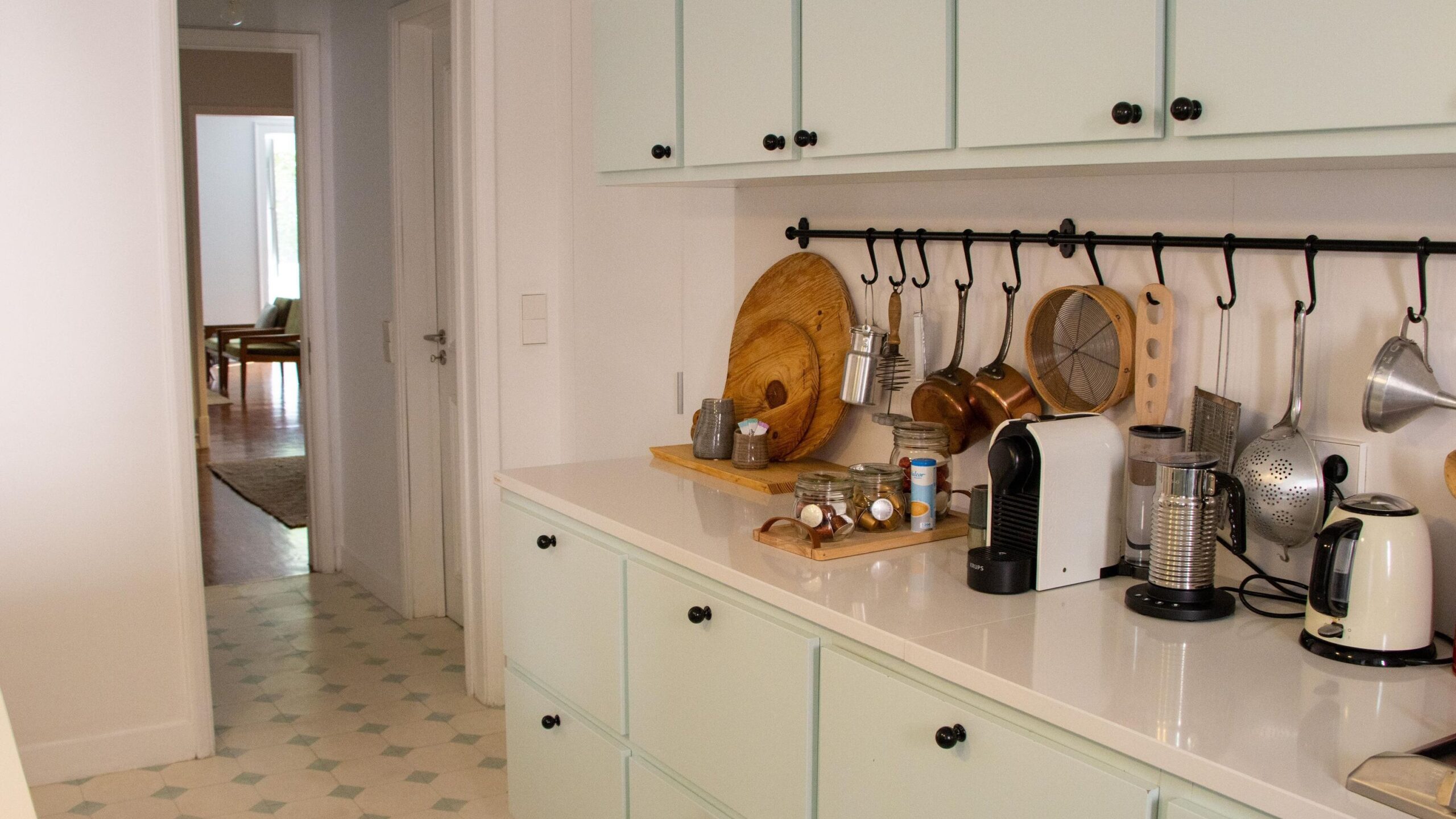 Modern kitchen in hotel with tiled floor.