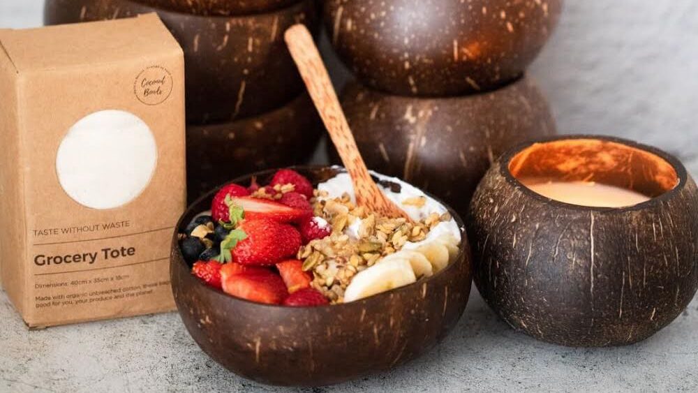 Stack of coconut bowls with fruit inside.