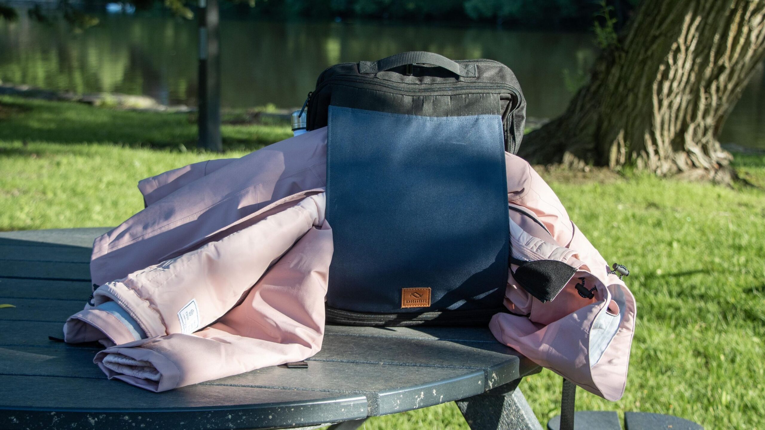 Black and blue backpack on bench with coat.