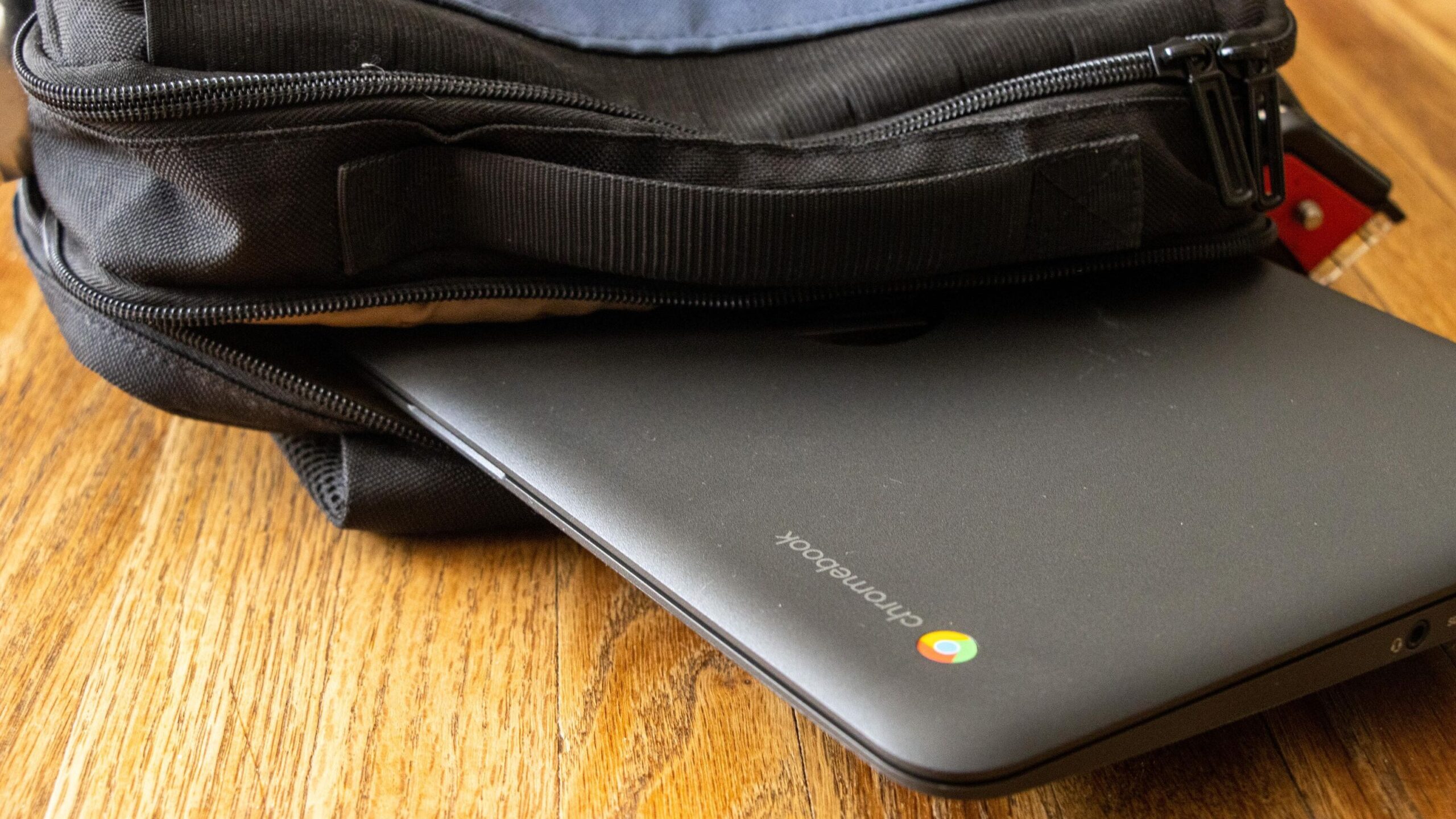 Laptop poking out of open backpack.