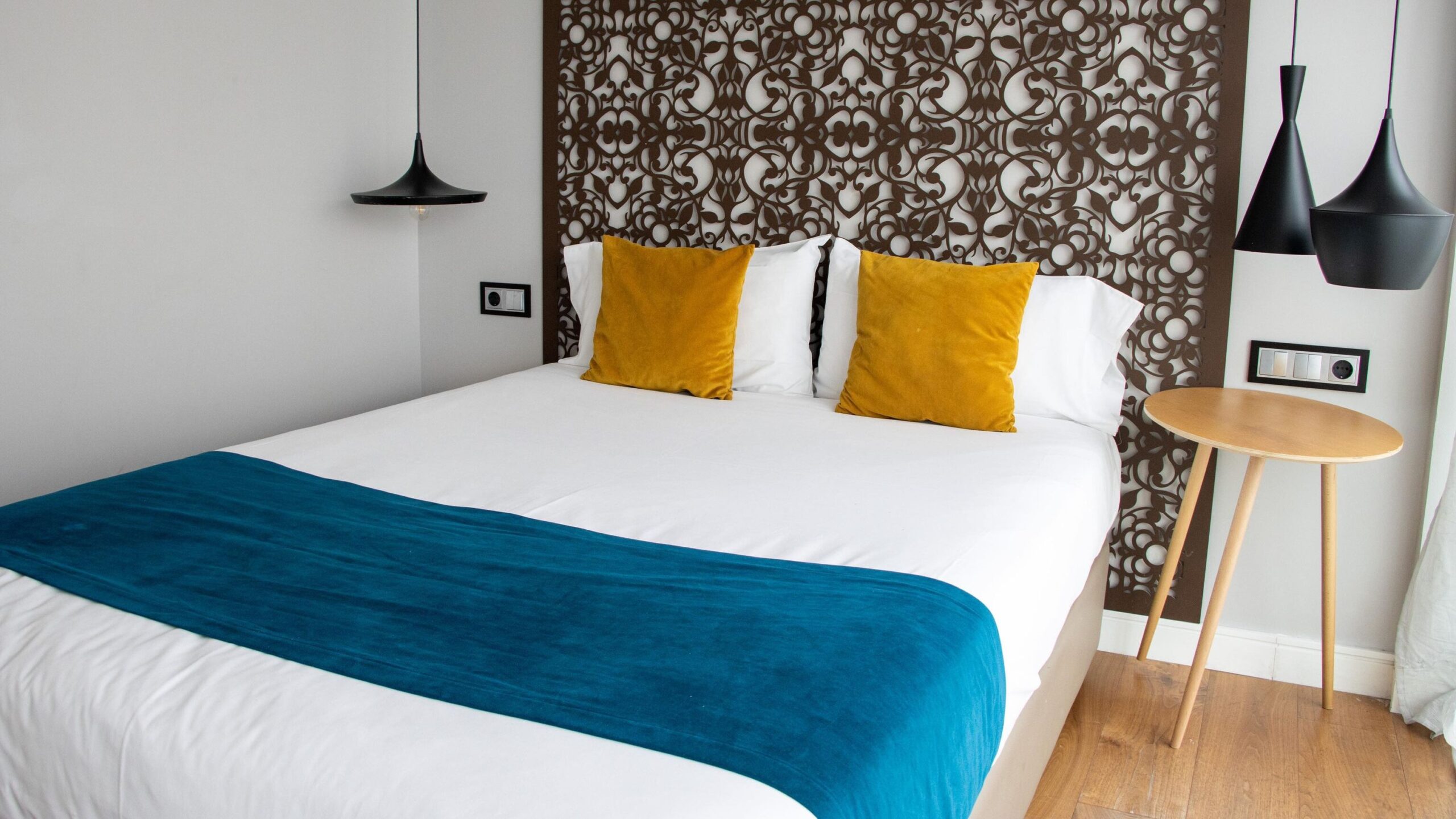 Double bed with yellow pillows against headboard. 