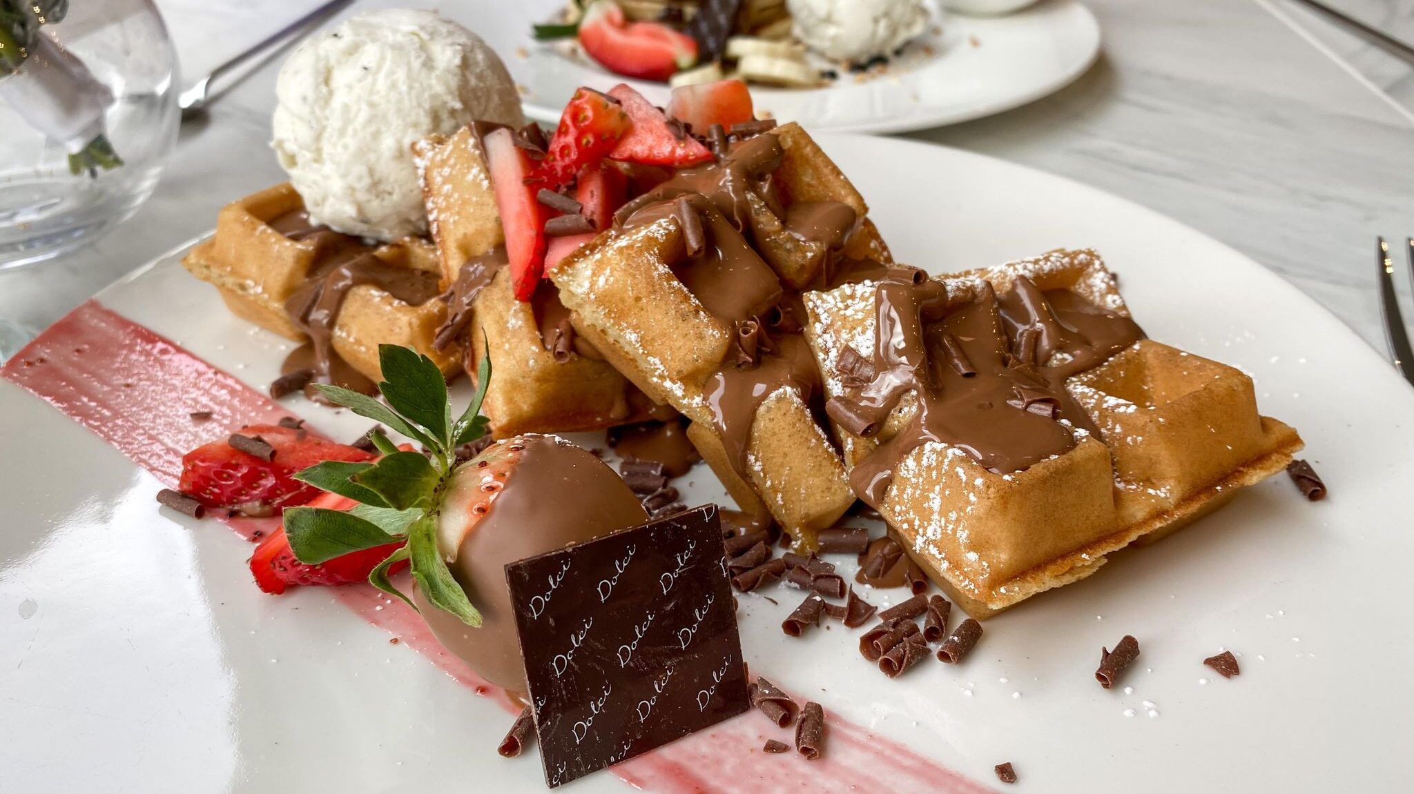 Waffles loaded with chocolate and strawberries. 