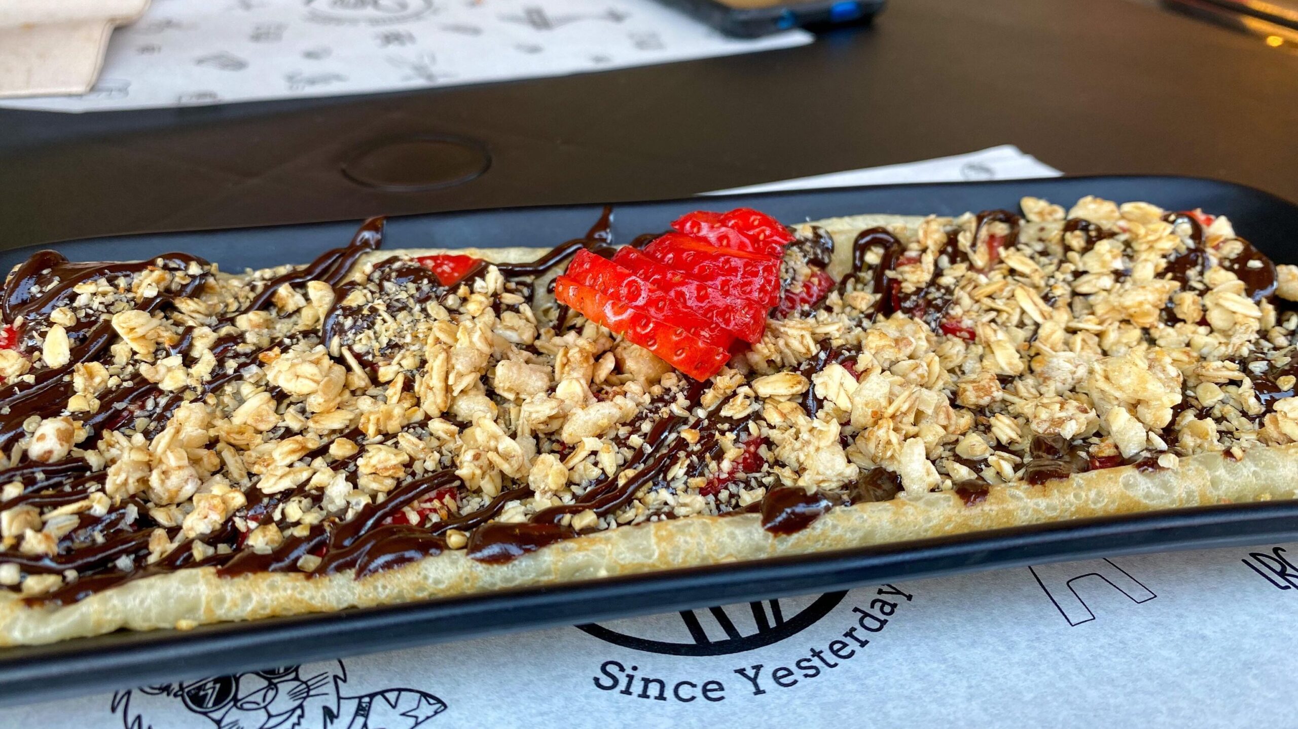 Crepe topped with chocolate and nuts.