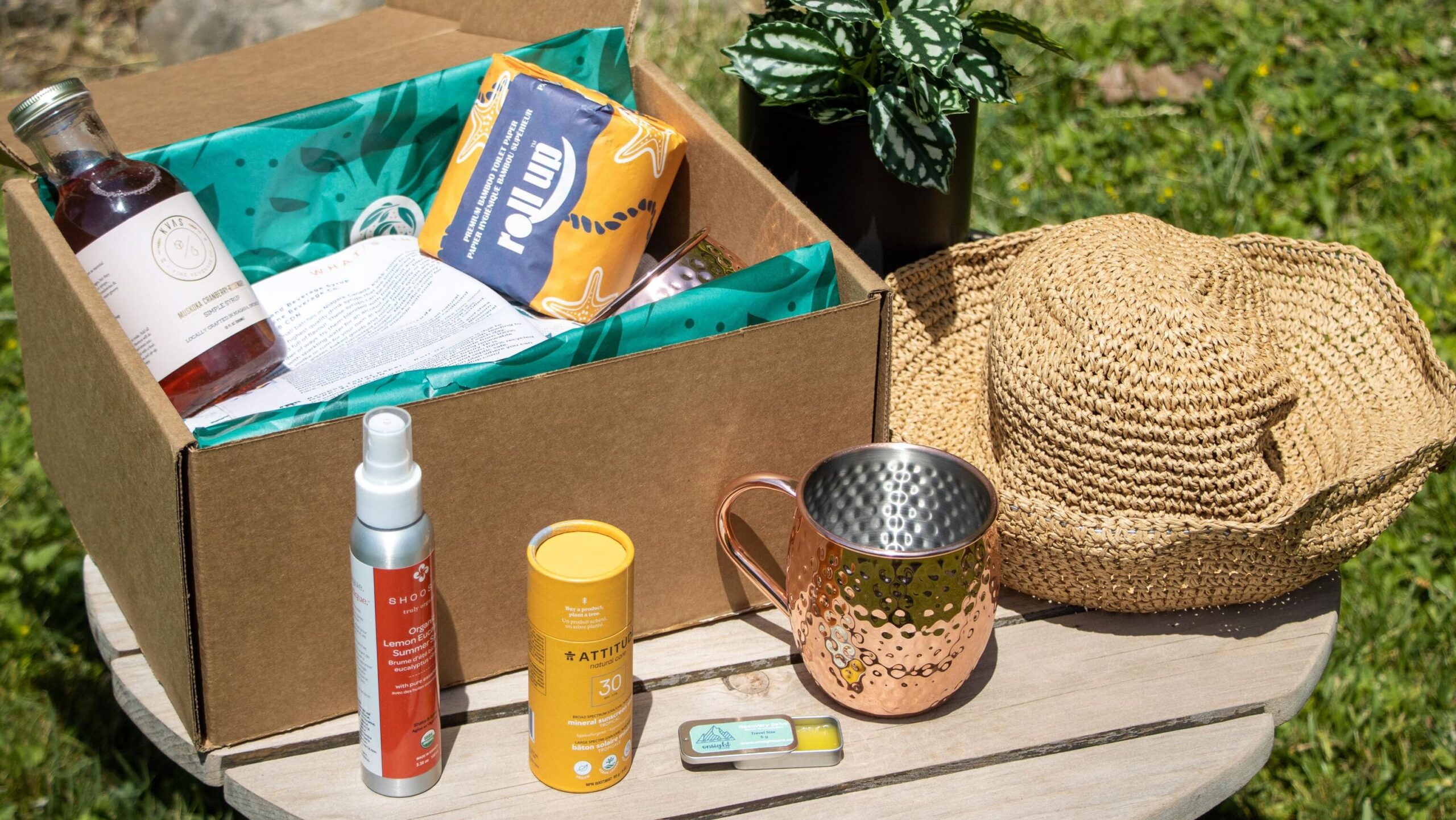 Box of summer items on outside table.