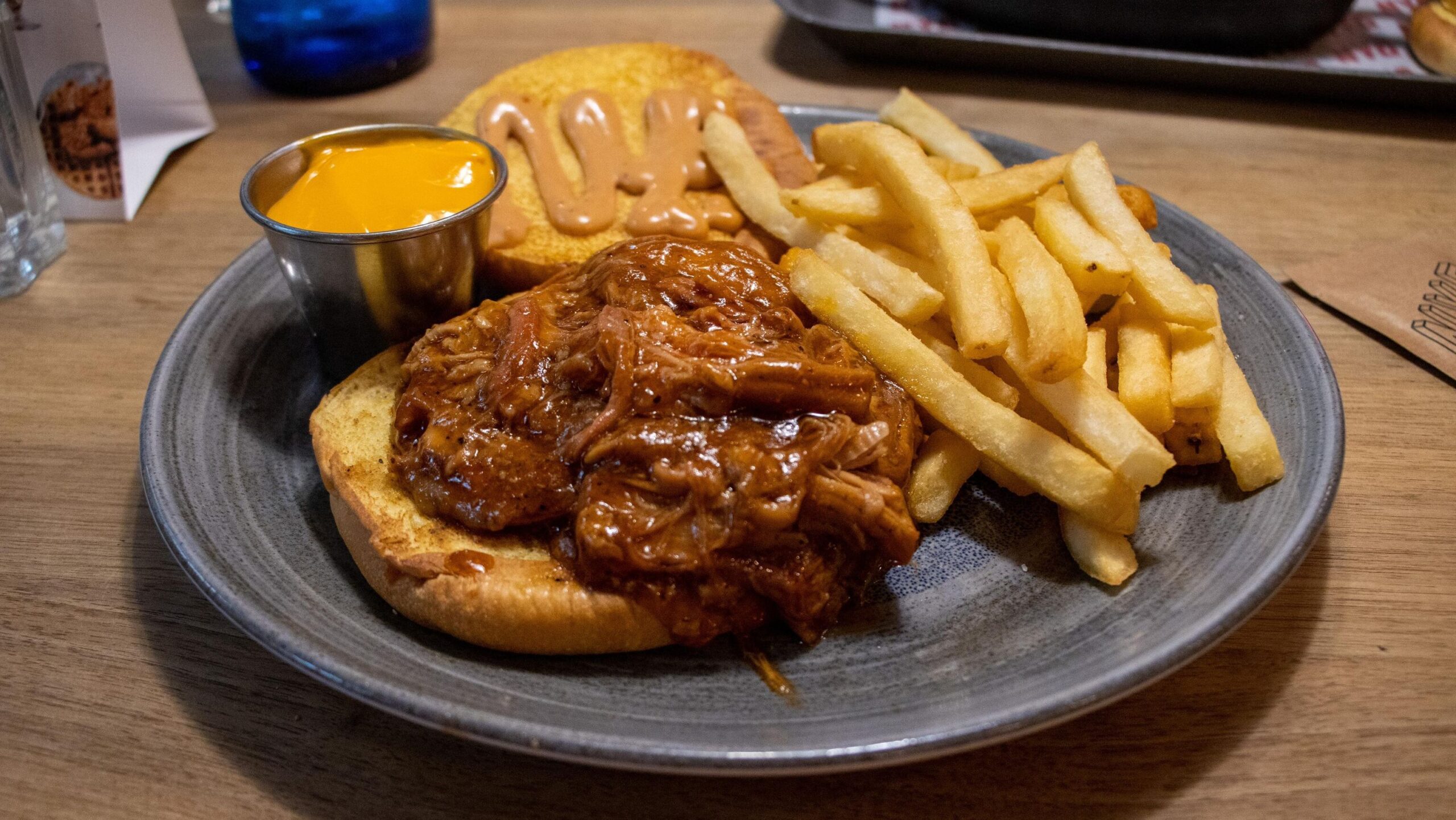 Pulled pork burger with chips and dip.