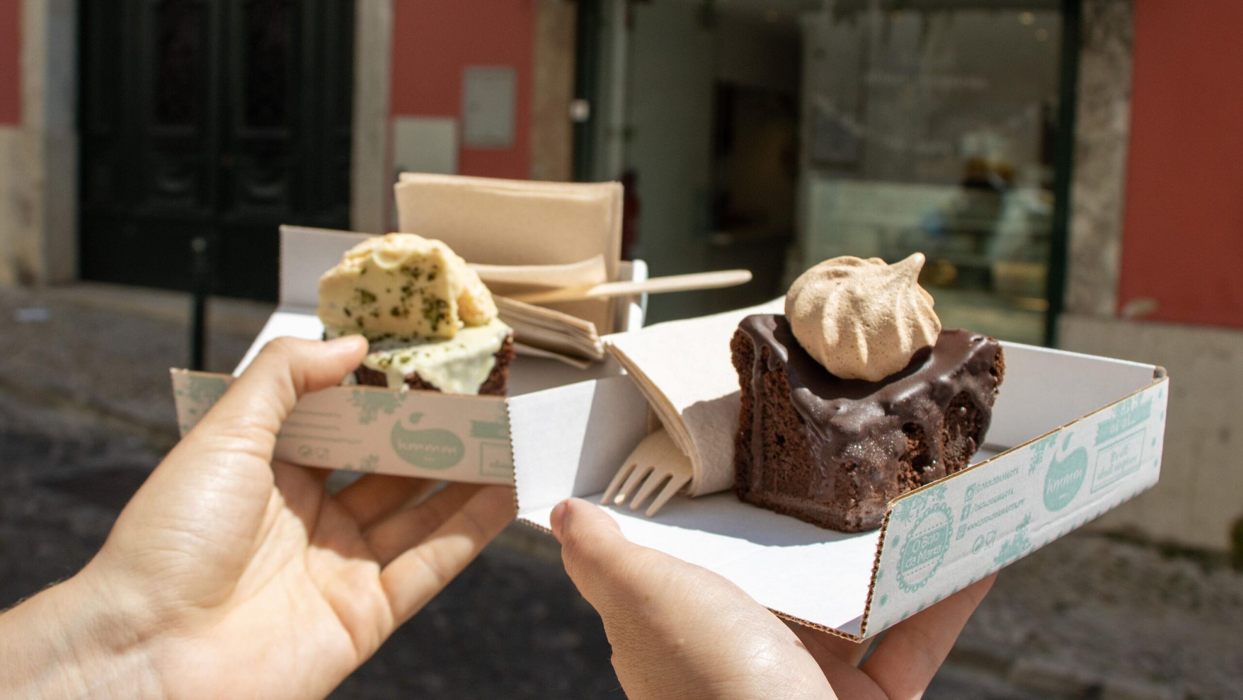 Two square slices of cake in boxes.