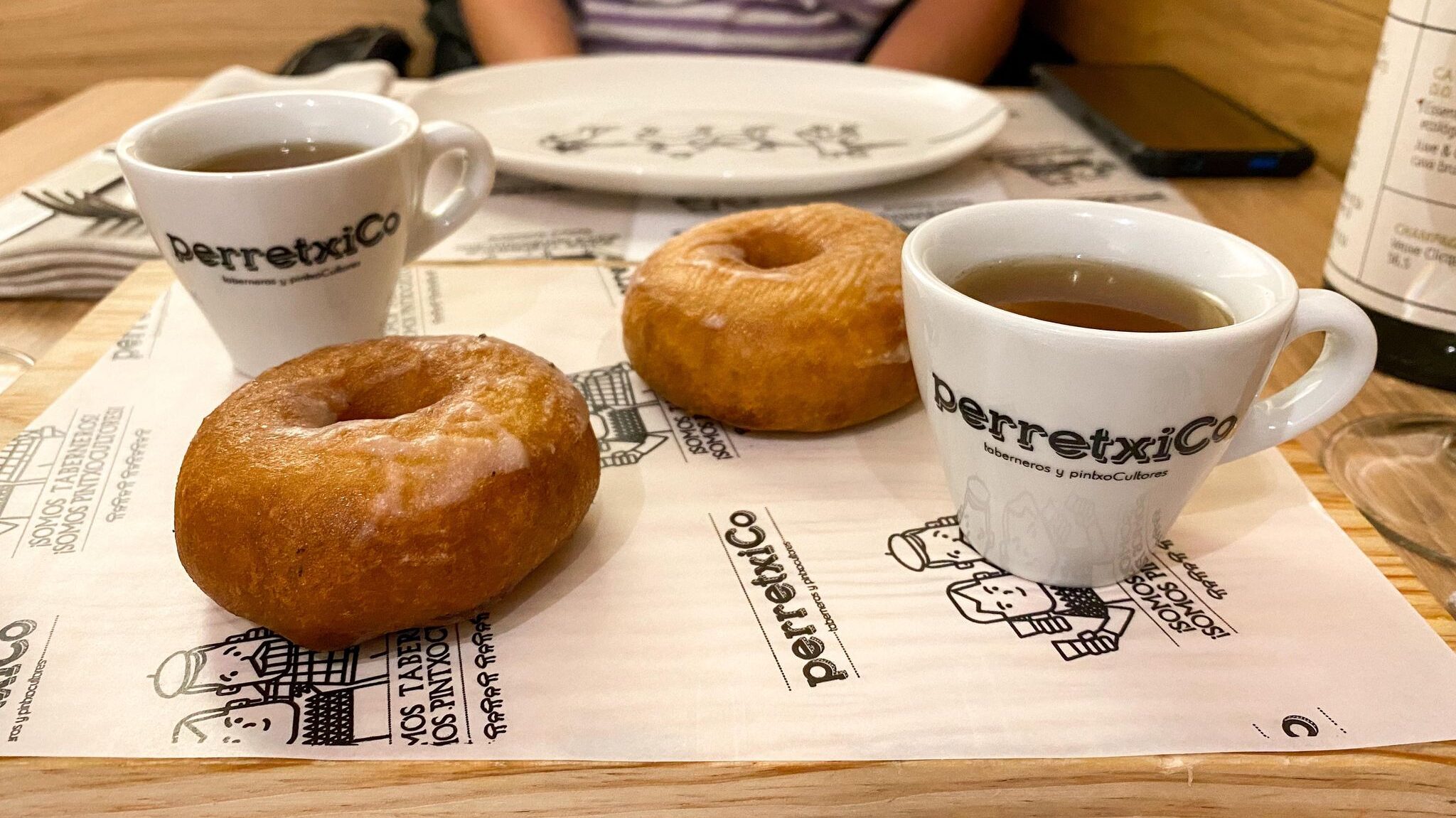 Two savoury donuts served with gravy in cups.