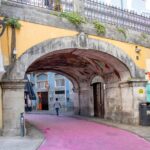 Street painted pink leading under bridge.