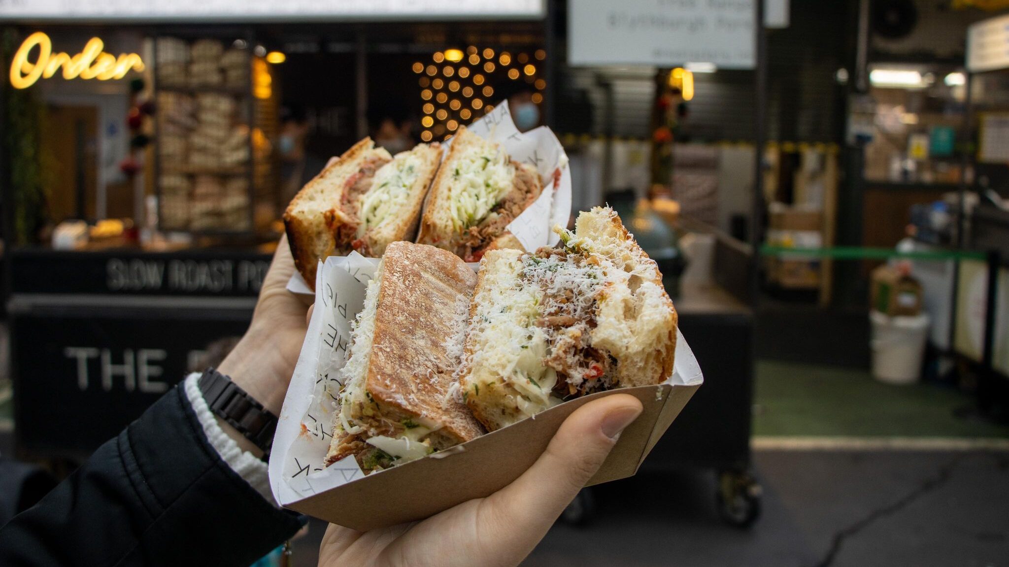 Two pork ciabatta sandwiches in market.  