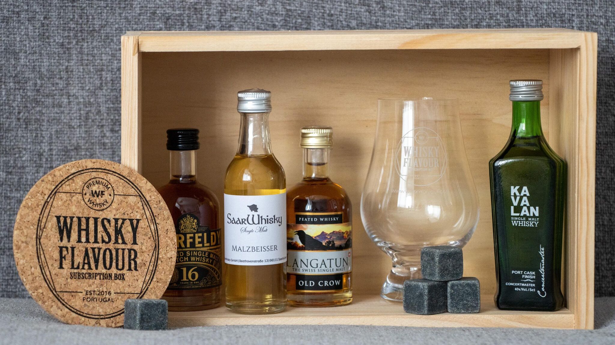 Wooden box with different types of small whisky bottles.