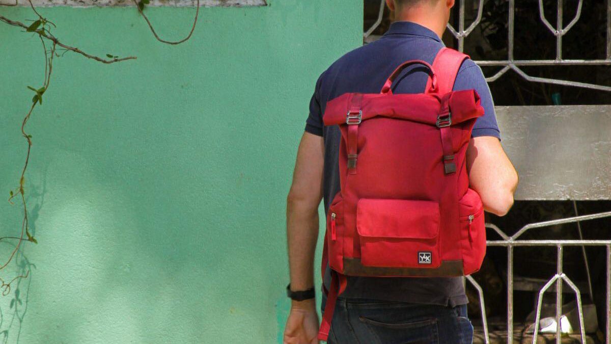 Red backpack being worn by man.